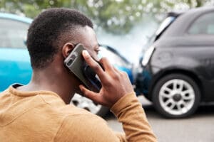 Male Motorist Involved In Car Accident Calling Insurance Company Or Recovery Service