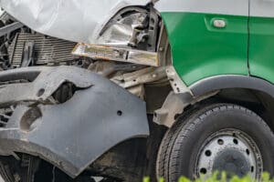 Heavily damaged car after commercial motor vehicle accident on a city street.
