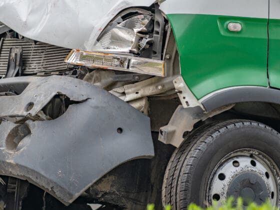 Heavily damaged car after commercial motor vehicle accident on a city street.
