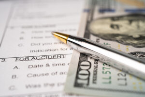 Insurance claim accident car form with US dollar banknote, Car loan, insurance and leasing time concepts.