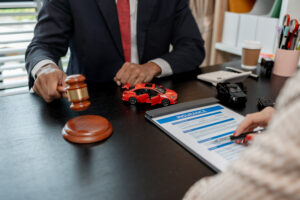 A car accident lawyer is explaining the details of a car insurance policy to the car owner before she signs it, a lawyer explains to his client what will happen if she doesn't get car insurance